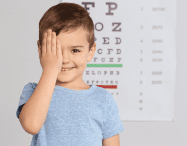 petit enfant couvrant son œil au bureau de l'optométriste